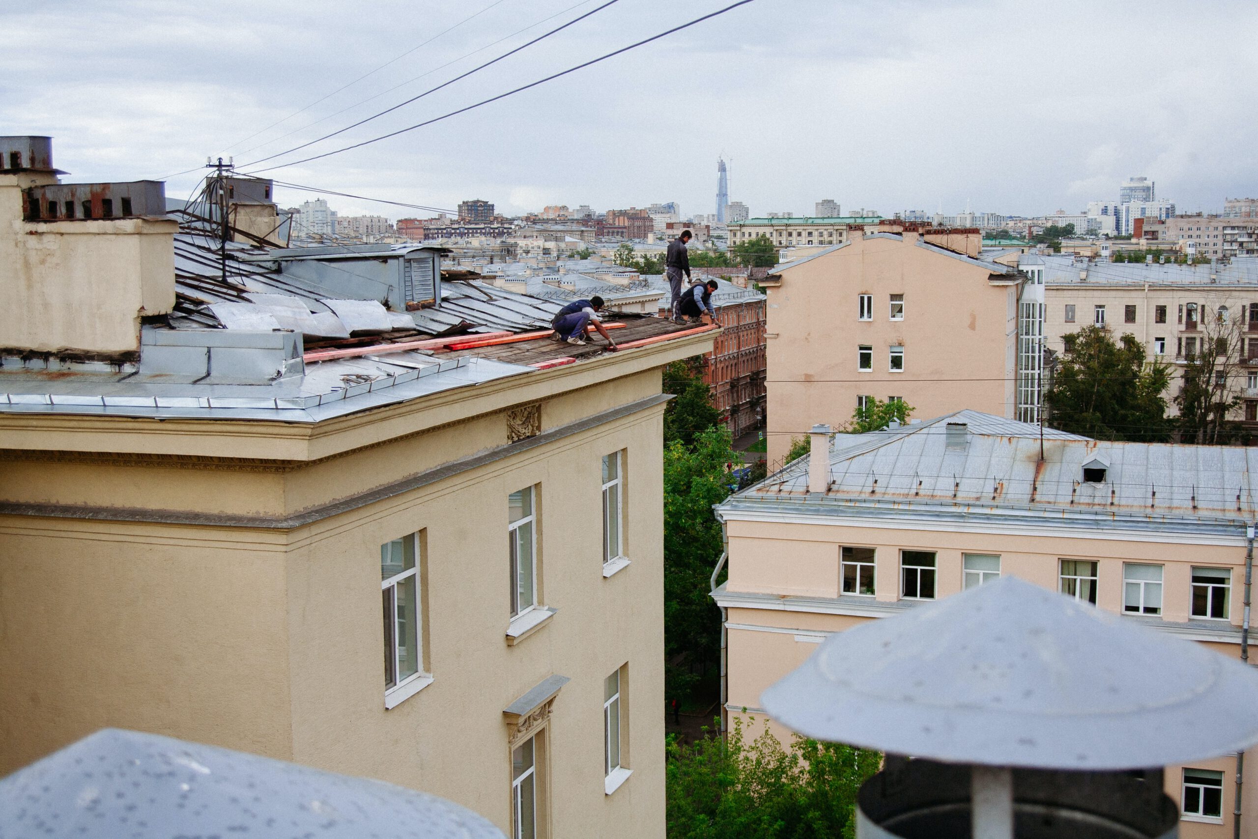 Dekarze pracujący na dachu bloku w mieście